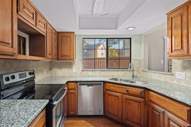 11310 Spicewood Club Dr Unit 10, Austin, TX 78750 - kitchen with appliances with stainless steel finishes, a sink, brown cabinetry, and a tray ceiling