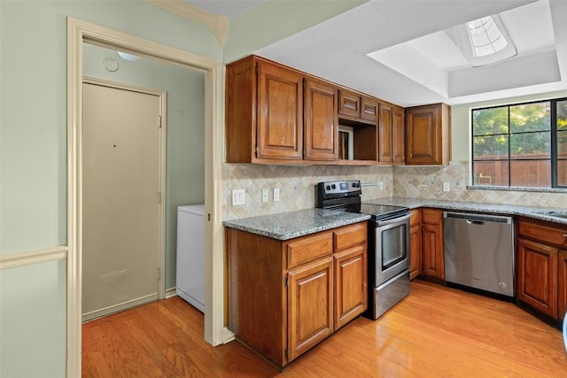 11310 Spicewood Club Dr Unit 10, Austin, TX 78750 - kitchen with stainless steel appliances, light wood-style flooring, light stone countertops, and brown cabinetry