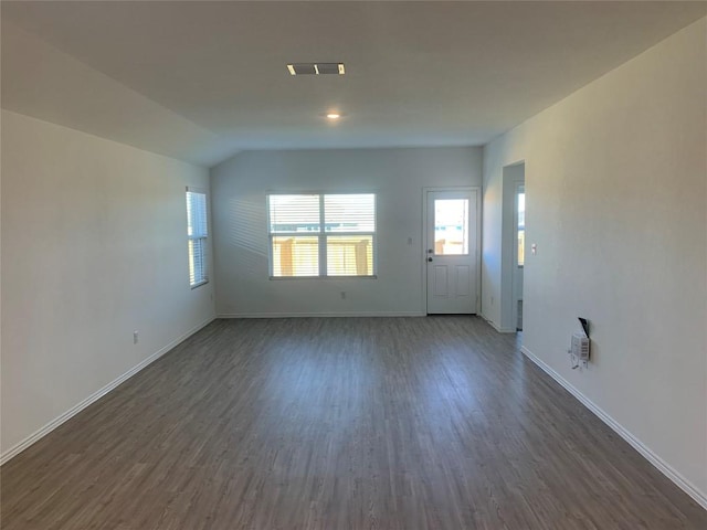 unfurnished living room with dark wood-type flooring and vaulted ceiling