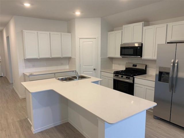 kitchen featuring white cabinets, sink, an island with sink, and stainless steel appliances