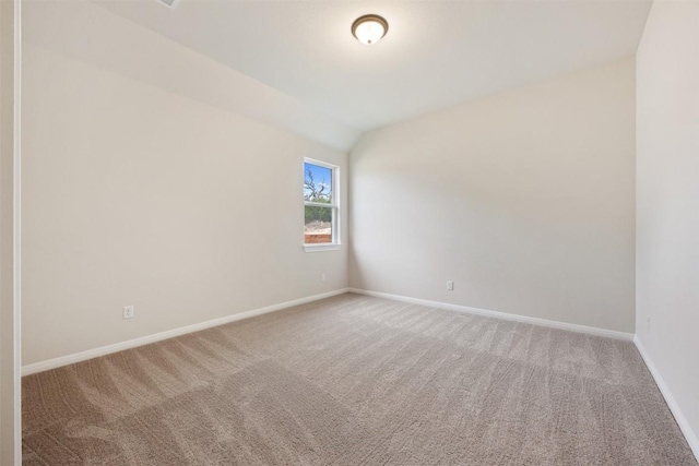 unfurnished room with carpet floors and vaulted ceiling