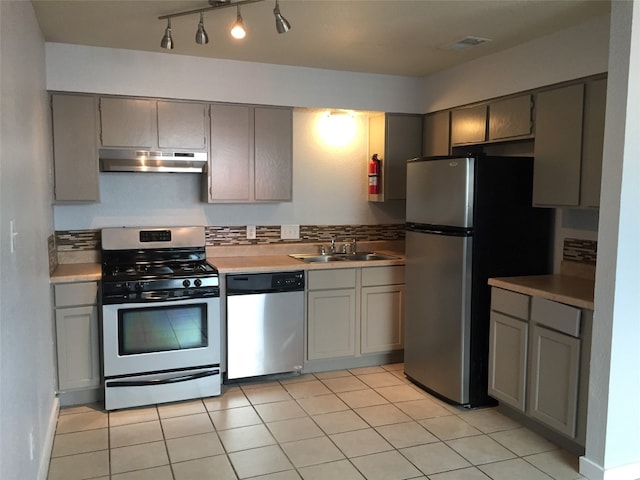 kitchen with light tile patterned floors, gray cabinets, sink, and appliances with stainless steel finishes