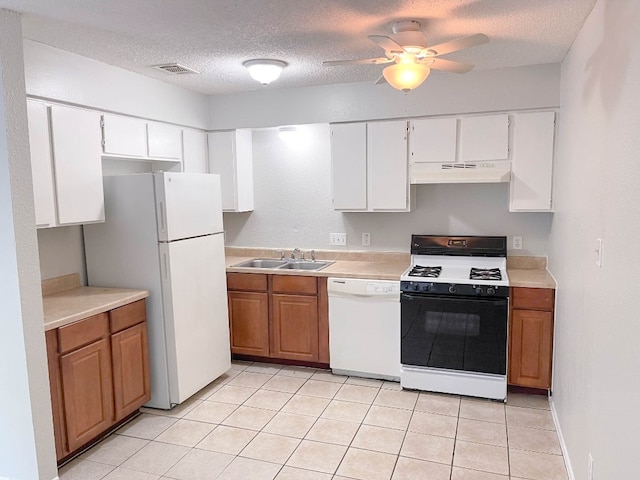 kitchen with a textured ceiling, white appliances, sink, and white cabinets