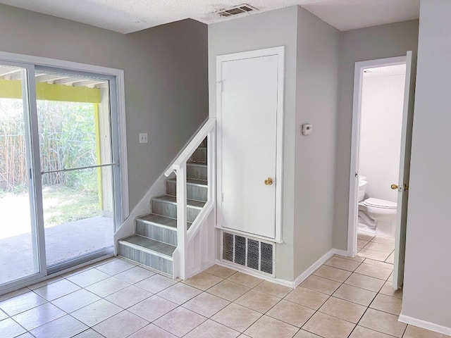 staircase featuring a wealth of natural light and tile patterned floors