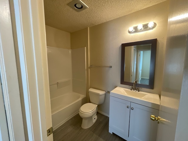 full bathroom featuring hardwood / wood-style floors,  shower combination, a textured ceiling, toilet, and vanity