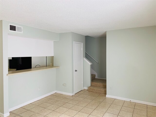 tiled spare room with a textured ceiling