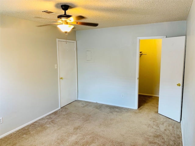 carpeted empty room featuring ceiling fan and a textured ceiling