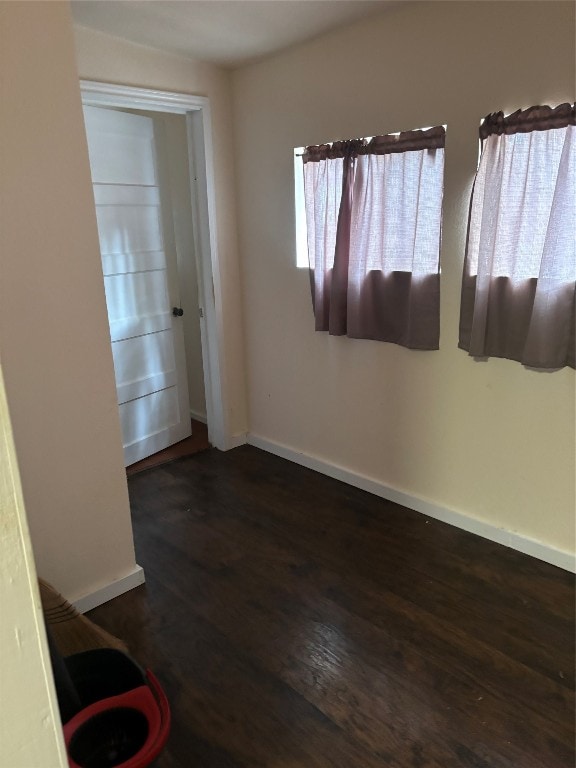 empty room with a wealth of natural light and dark wood-type flooring