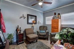 living area featuring ceiling fan, crown molding, and light hardwood / wood-style flooring