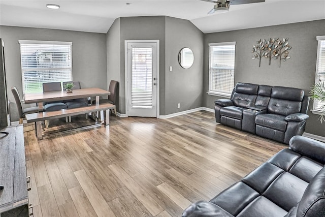 living room featuring light hardwood / wood-style floors, plenty of natural light, and lofted ceiling