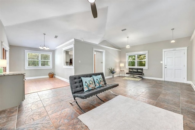 living room with ceiling fan with notable chandelier, dark hardwood / wood-style floors, and lofted ceiling