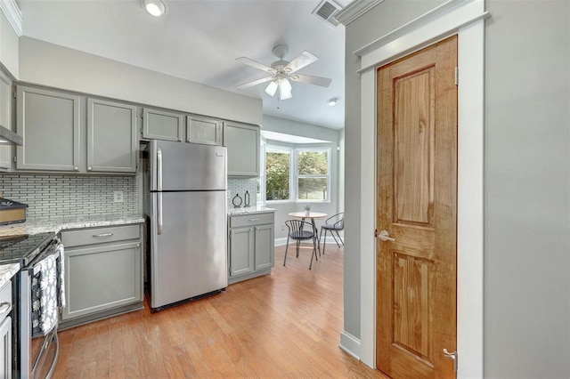 kitchen featuring stainless steel refrigerator, gray cabinetry, and light wood-type flooring