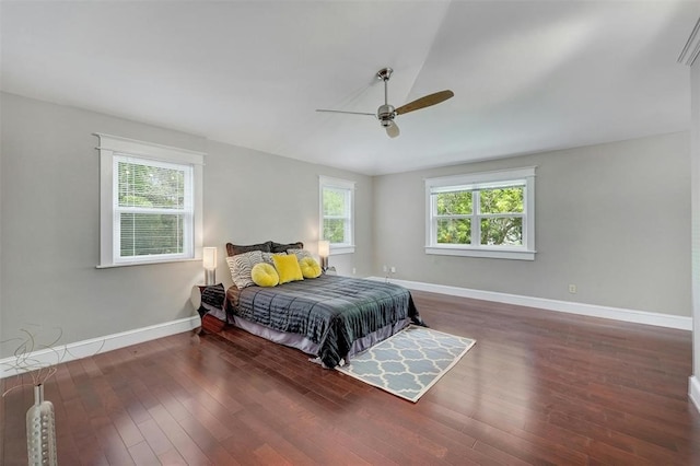 bedroom with dark hardwood / wood-style flooring, ceiling fan, and vaulted ceiling