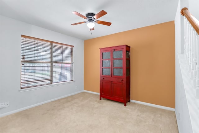 unfurnished room with ceiling fan and light carpet