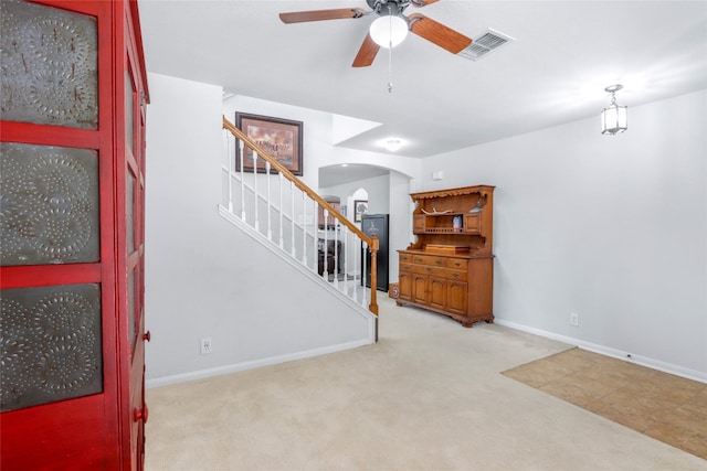 entryway with light colored carpet and ceiling fan