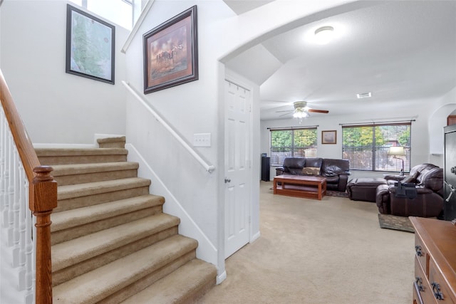 stairs featuring carpet flooring and ceiling fan