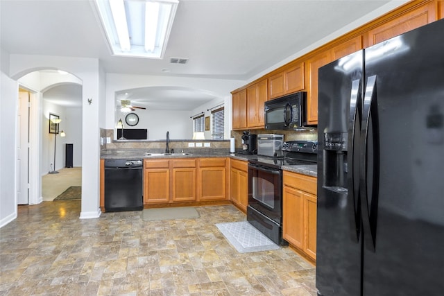 kitchen featuring black appliances, backsplash, sink, and ceiling fan