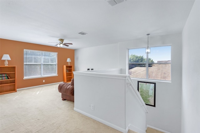 interior space featuring light carpet and ceiling fan