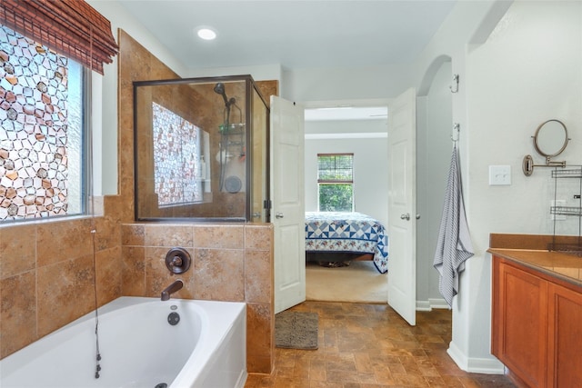 bathroom featuring shower with separate bathtub and vanity