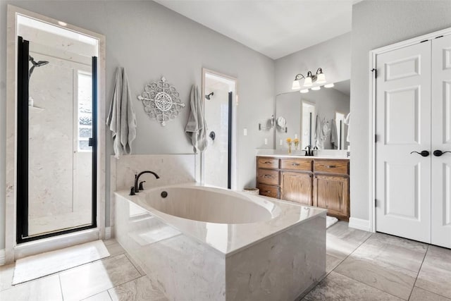 bathroom featuring vanity and independent shower and bath