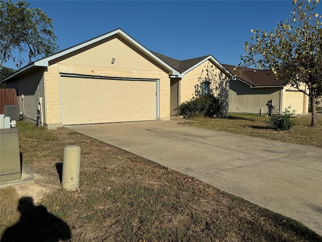 ranch-style home featuring central AC unit and a garage