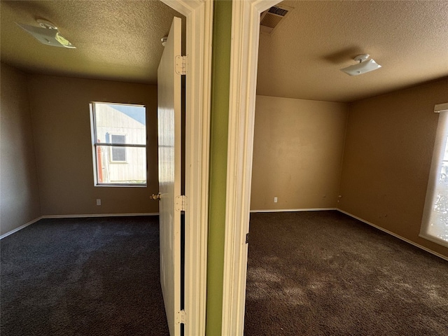 carpeted spare room featuring a textured ceiling