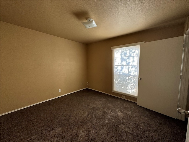 carpeted spare room featuring a textured ceiling