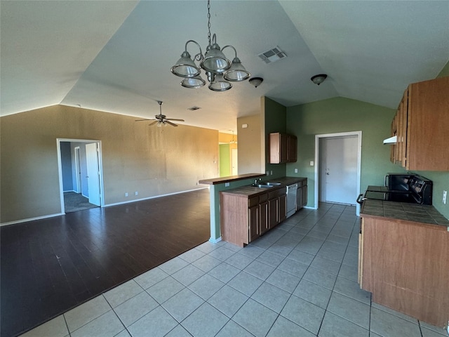 kitchen with sink, white dishwasher, black range oven, lofted ceiling, and light wood-type flooring