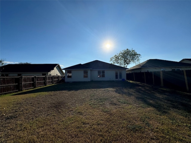 rear view of property featuring a lawn