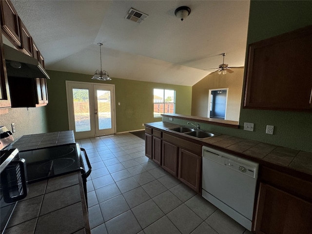 kitchen featuring white dishwasher, sink, vaulted ceiling, tile counters, and ceiling fan with notable chandelier