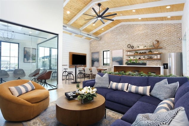 living room featuring high vaulted ceiling, wood ceiling, a ceiling fan, brick wall, and beamed ceiling