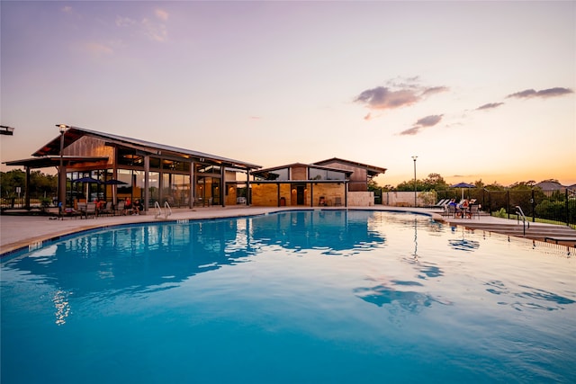 pool at dusk with a patio area