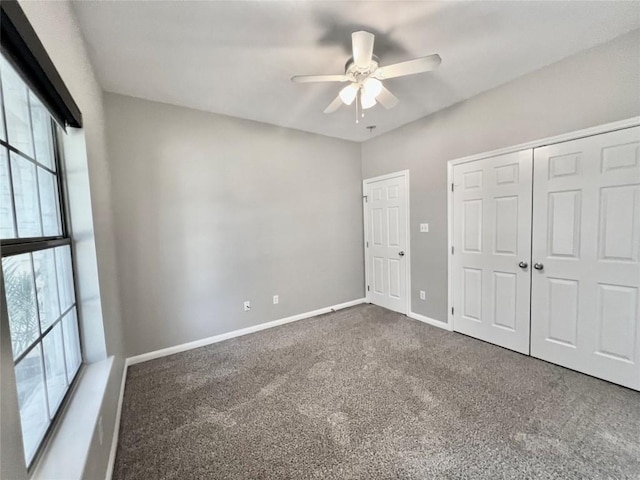 unfurnished bedroom featuring dark carpet and ceiling fan