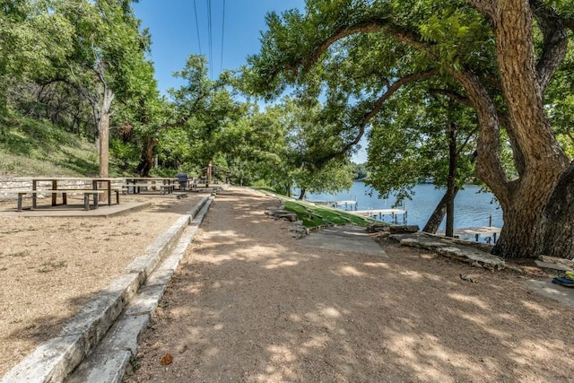 view of community with a dock and a water view