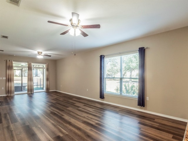 unfurnished room with dark wood-type flooring, a wealth of natural light, and ceiling fan