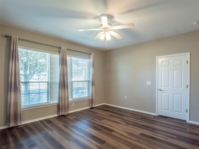 empty room with ceiling fan and dark hardwood / wood-style floors