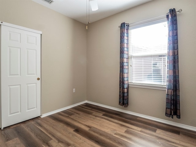 unfurnished room with dark wood-type flooring and ceiling fan