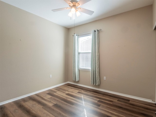 spare room featuring dark wood-type flooring and ceiling fan