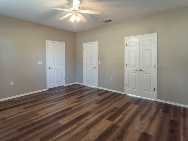 unfurnished bedroom featuring dark wood-type flooring and ceiling fan