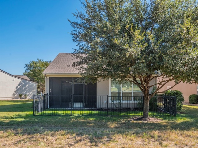 rear view of property with a sunroom and a lawn