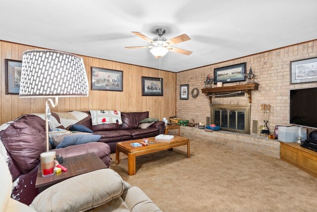 carpeted living room with wooden walls, ceiling fan, and a brick fireplace