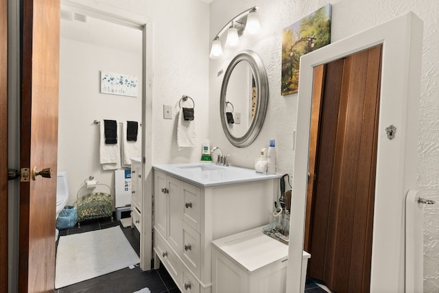 bathroom featuring vanity, tile patterned flooring, and toilet