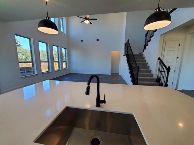 kitchen featuring dark wood-type flooring, ceiling fan, sink, and pendant lighting