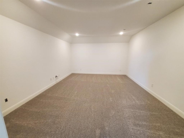 empty room featuring carpet floors and vaulted ceiling