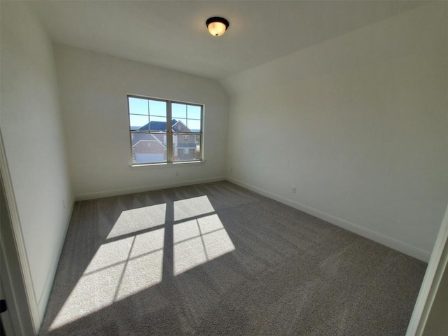 carpeted spare room featuring lofted ceiling