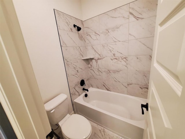 bathroom with tiled shower / bath combo and toilet