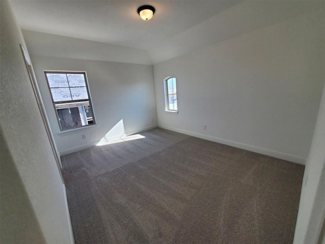 carpeted spare room with lofted ceiling