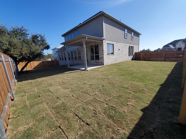 rear view of property with a lawn and a patio