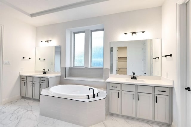 bathroom featuring vanity and tiled tub