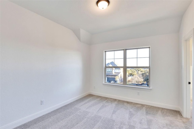 empty room featuring lofted ceiling and carpet flooring